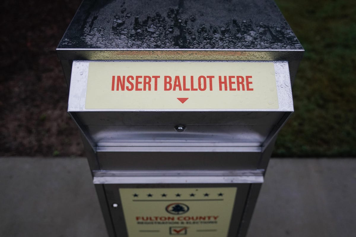 Absentee ballot drop box with a sign that says, "Insert ballot here."