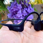 Aftershokz Aeropex headset on someone's hand outdoors