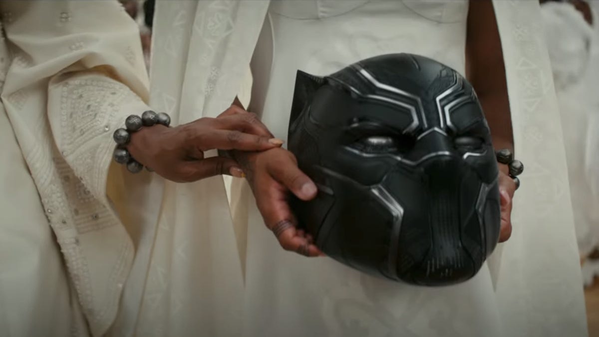Mourners carry T'Challa's mask in Black Panther: Wakanda Forever