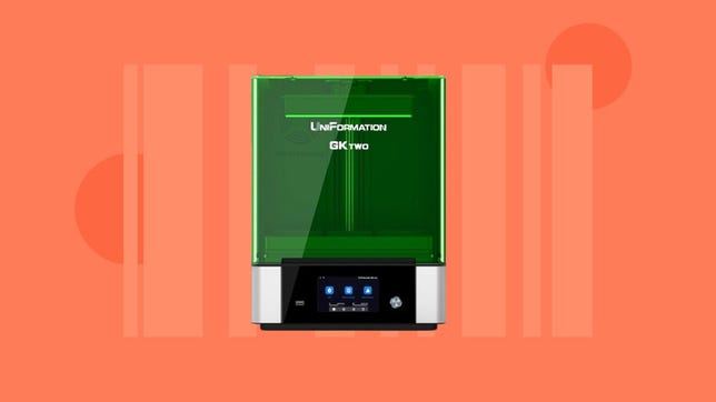 A green and silver 3D printer on an orange background