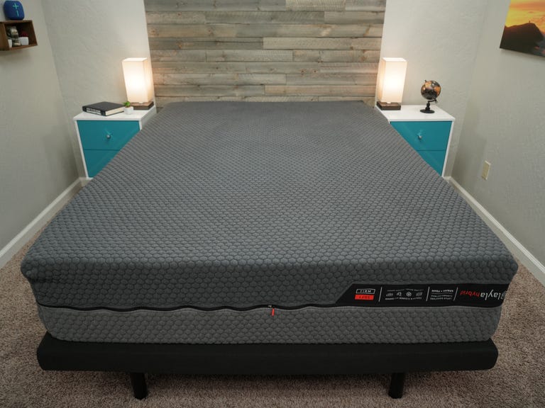 A Layla Hybrid mattress in between two blue and white night stands