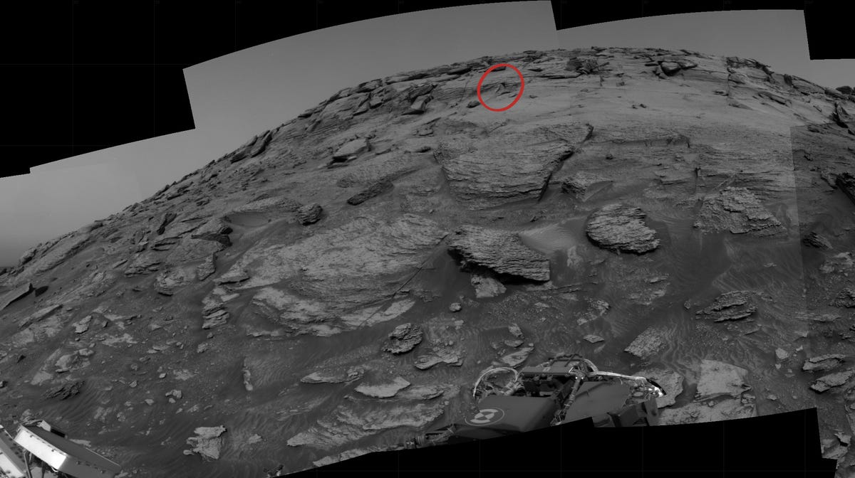 Distant view of a Mars formation shows a small angular area in the rock.