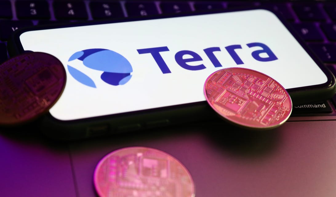 Terra logo on a phone screen, plus a couple of coins