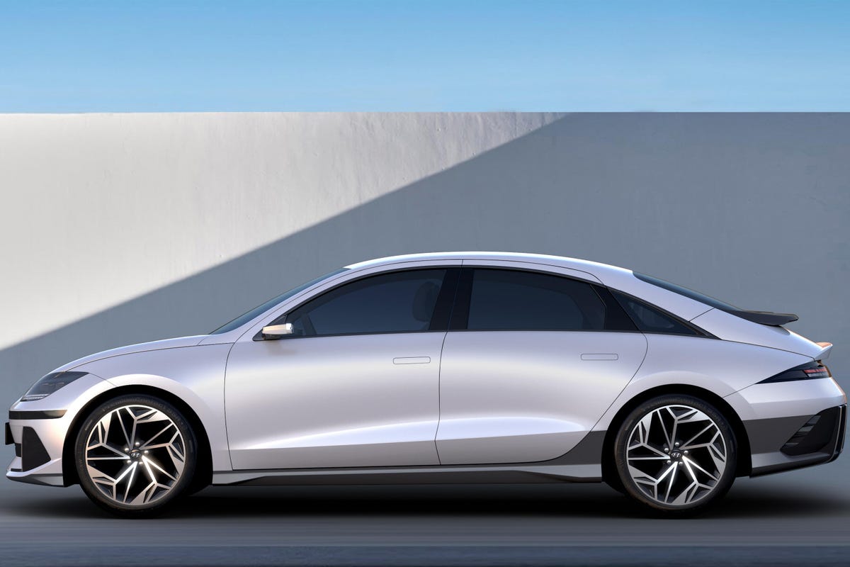 Side view of a white Hyundai Ioniq 6 electric sedan in front of a wall
