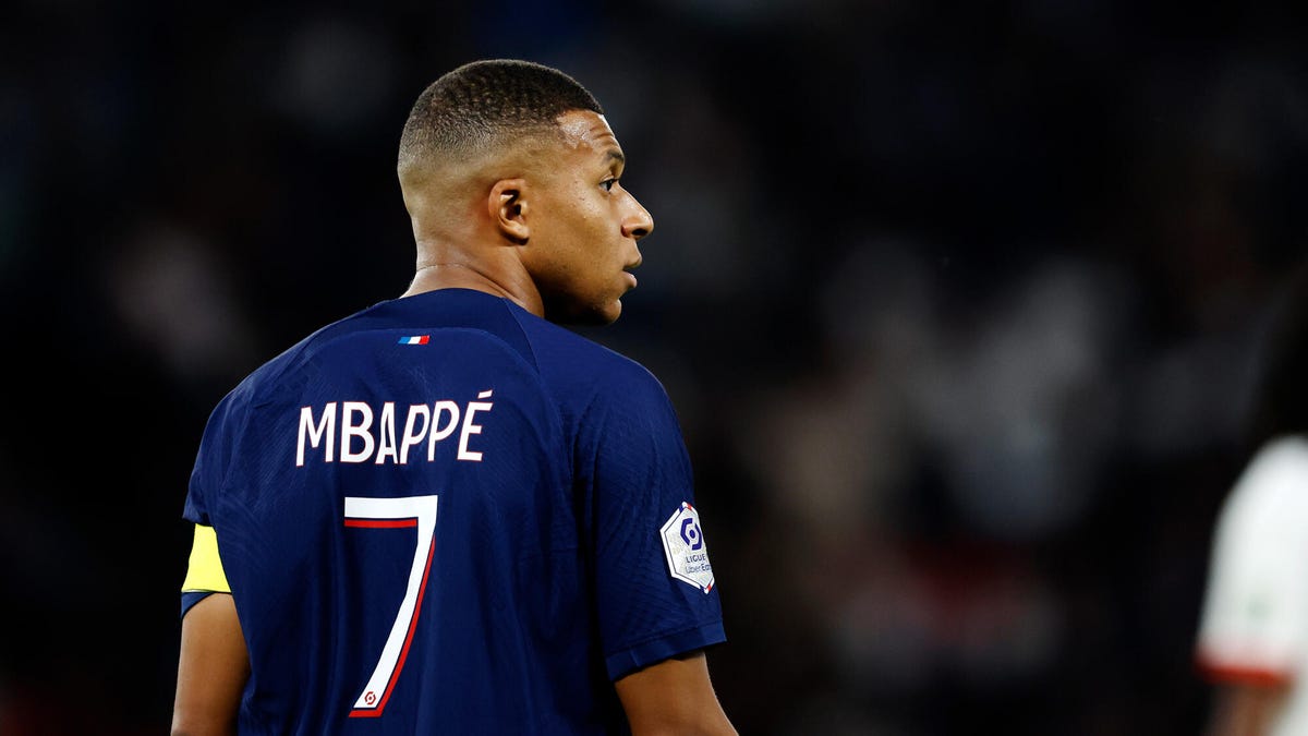 Paris Saint Germain forward Kylian Mbappe with his his back to the camera turning to his right.