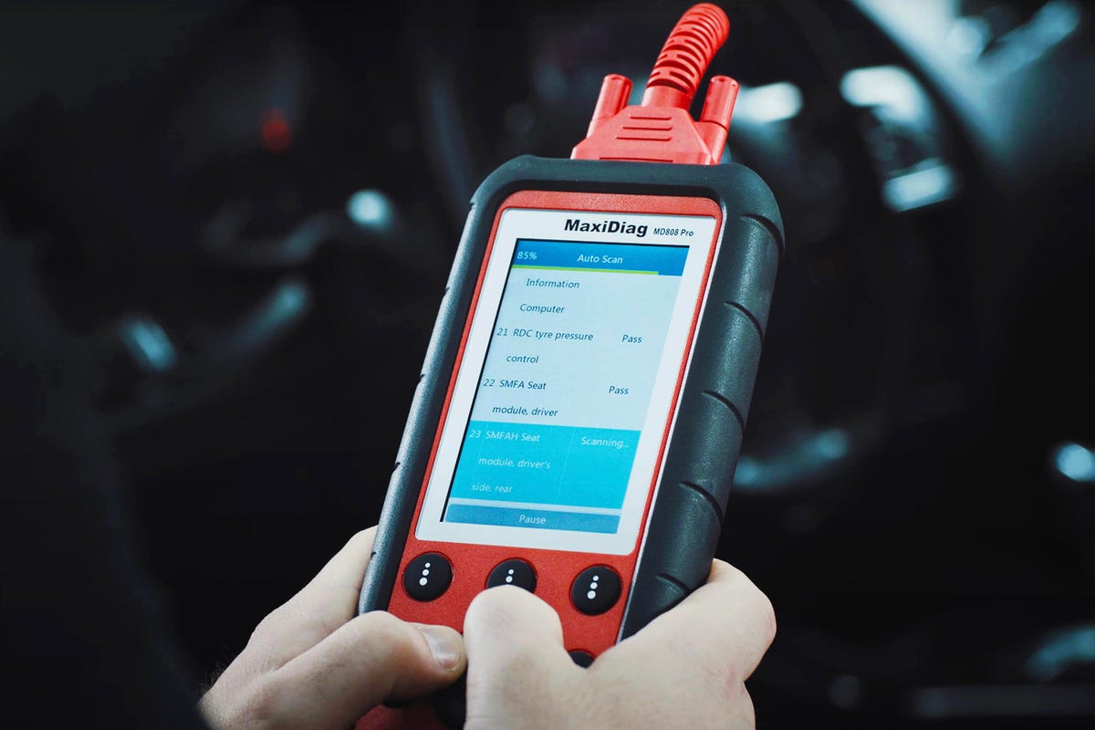 A person using an OBD2 scanner up close. 