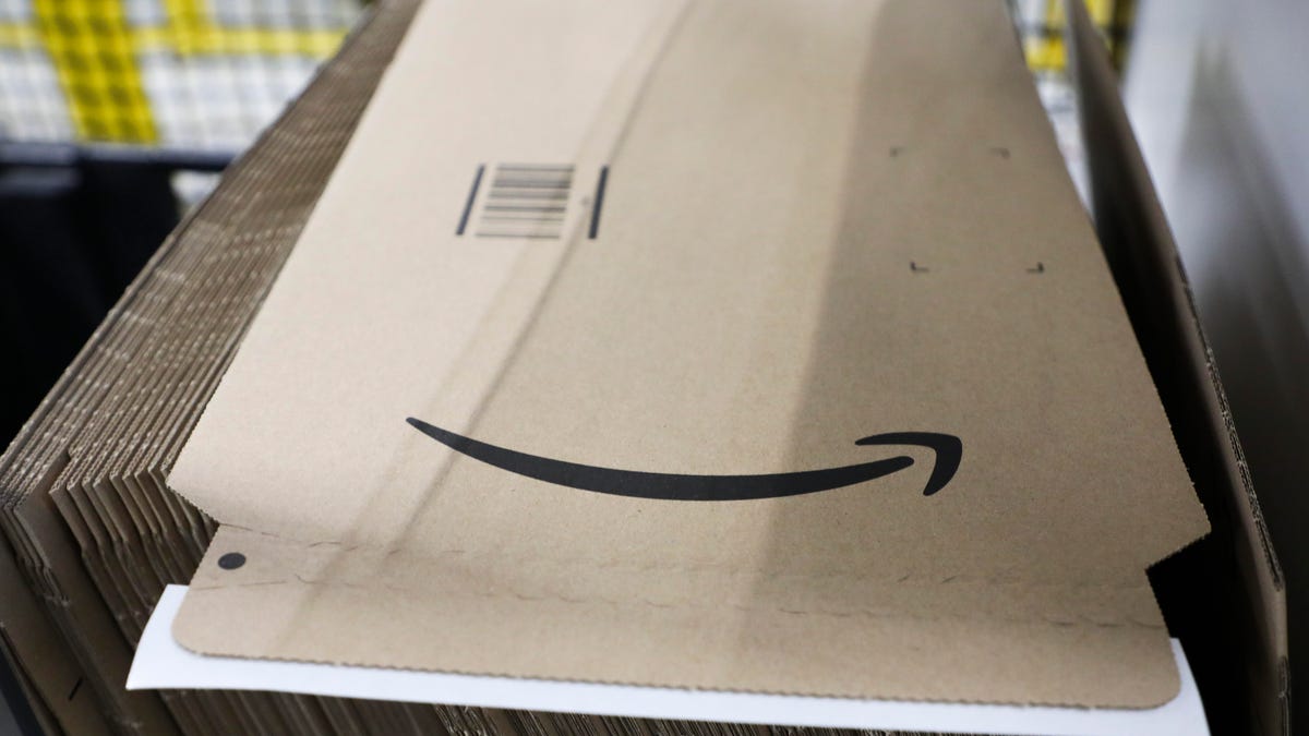 A stack of flat Amazon boxes, with one on top showing the Amazon smile logo.