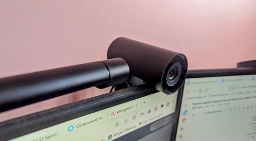 A webcam attached to a monitor with a pink background