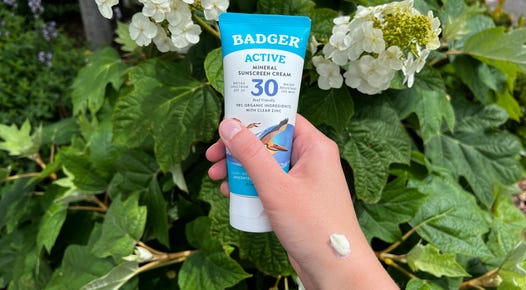 A hand holding Badger Active Sunscreen