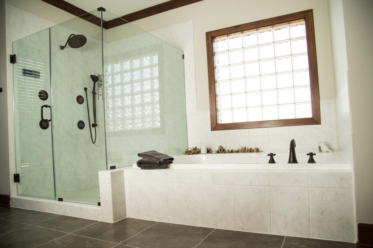 A bathtub and shower in a bathroom with a tiled floor