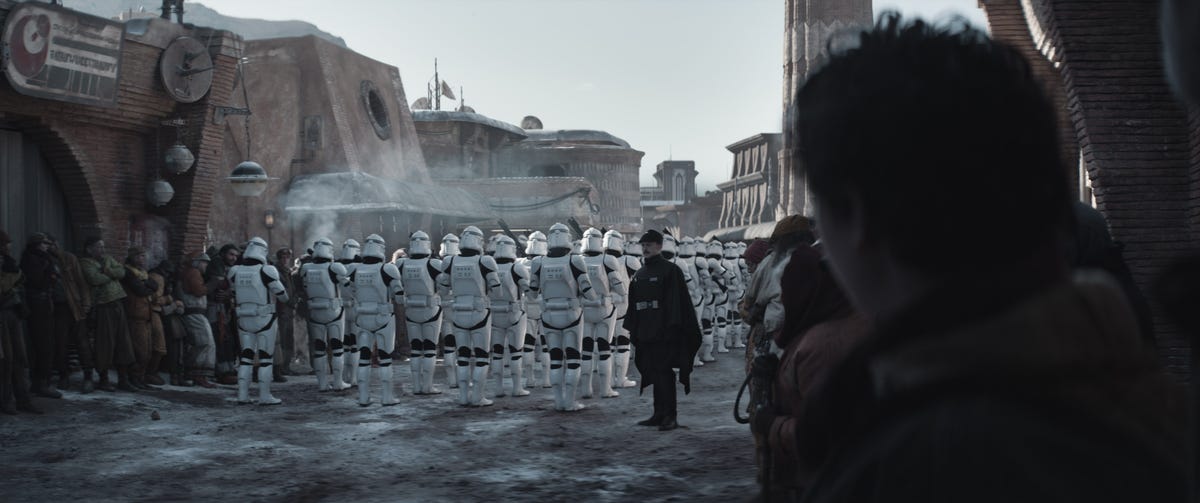 A crowd watches lines of clone troopers on a muddy street in Andor