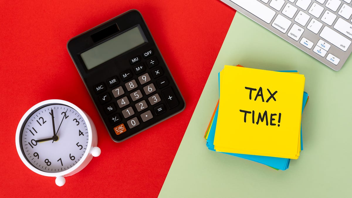 A clock, a calculator, a keyboard and a note that says TAX TIME!