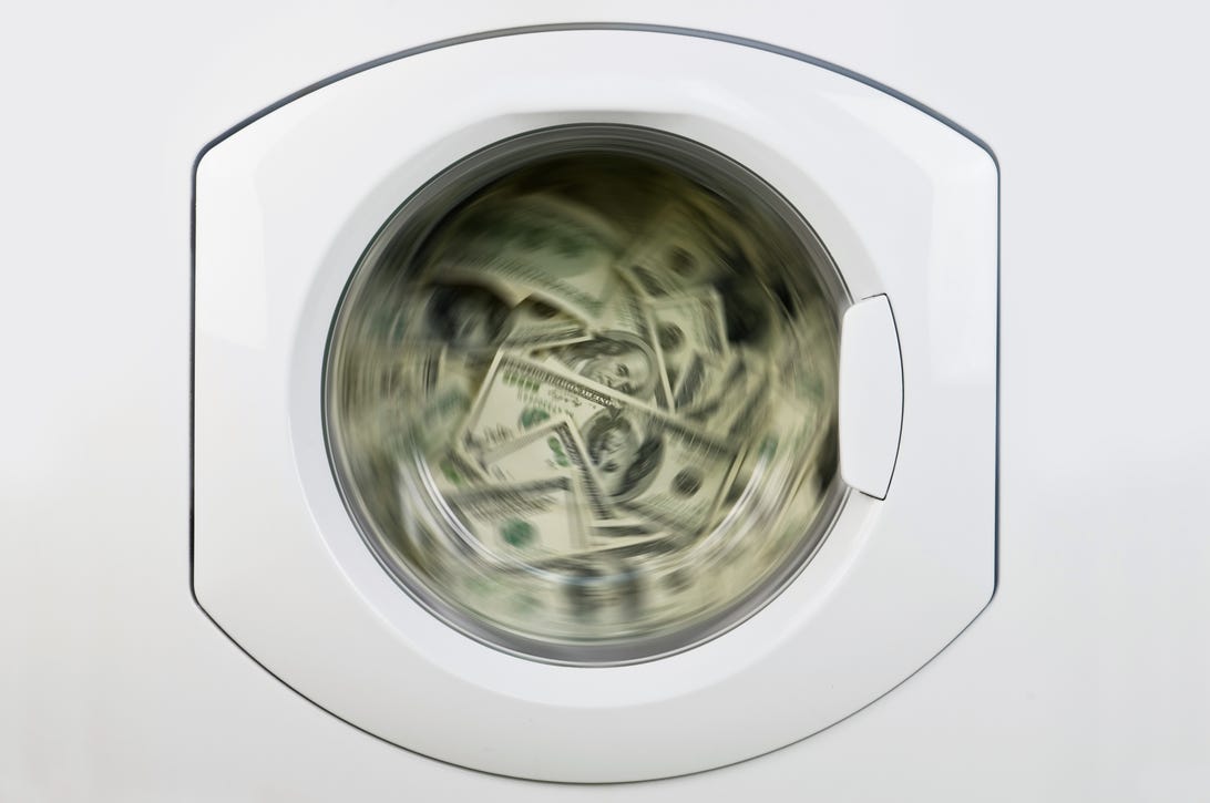 100-dollar bills in a washing machine spin cycle - getty 152959834