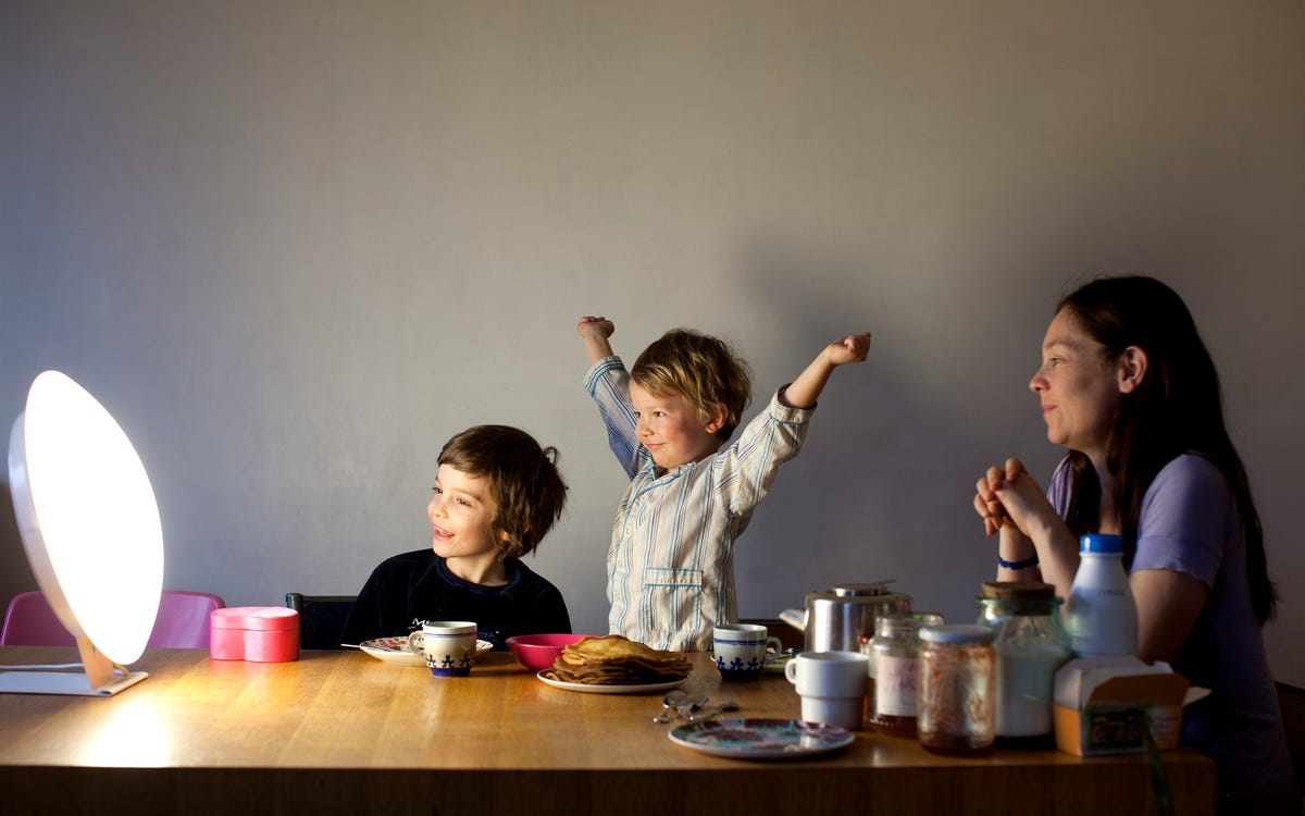 Family having breakfast with light therapy lamp.