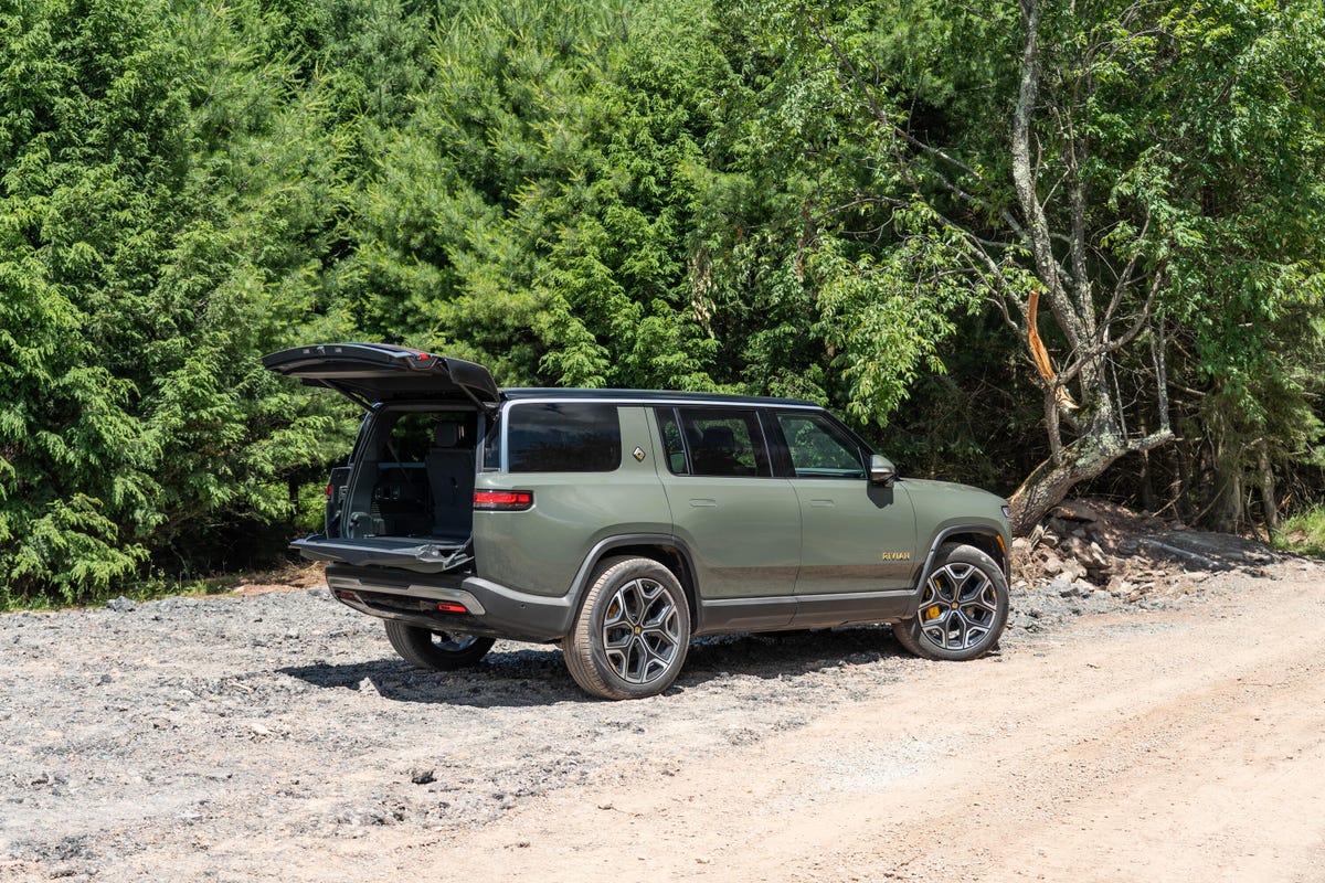 The all-electric 2022 Rivian R1S SUV looking cool in a light green and bright sunshine.