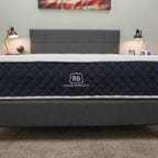 The Brooklyn Bedding Signature mattress on top of a grey bed frame.
