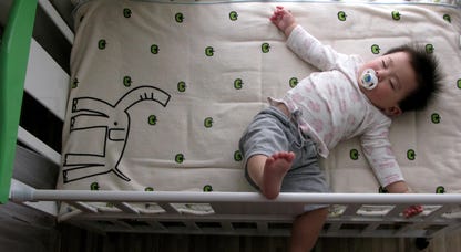 A baby laying in a crib
