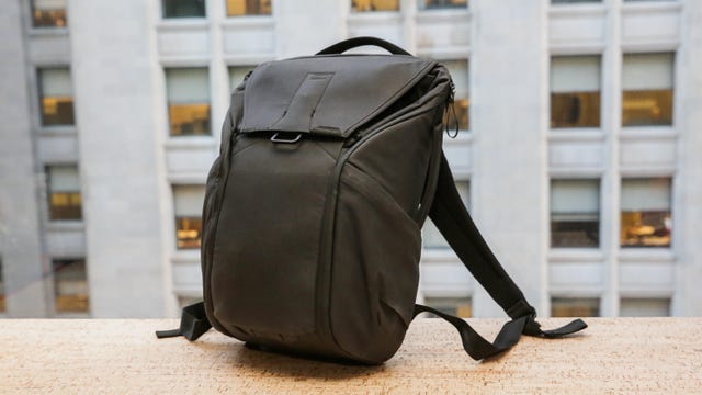 A black backpack sits on a building ledge.