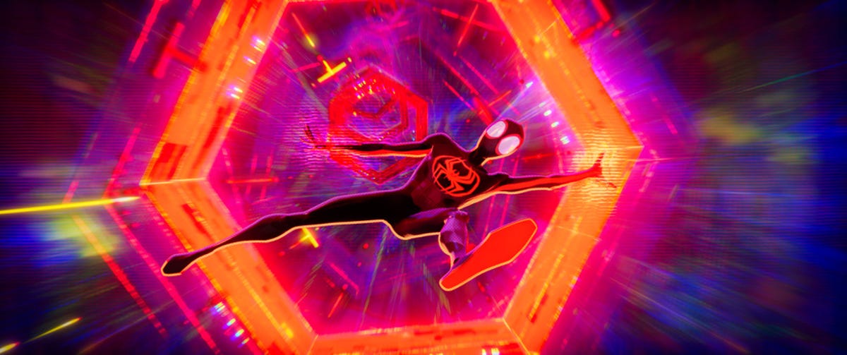 A costumed Miles Morales falls through an orange interdimensional portal in Spider-Man: Across the Spider-Verse, against a mostly purple background