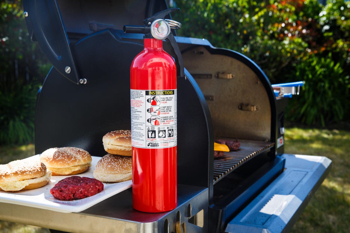 Fire extinguisher next to a black grill