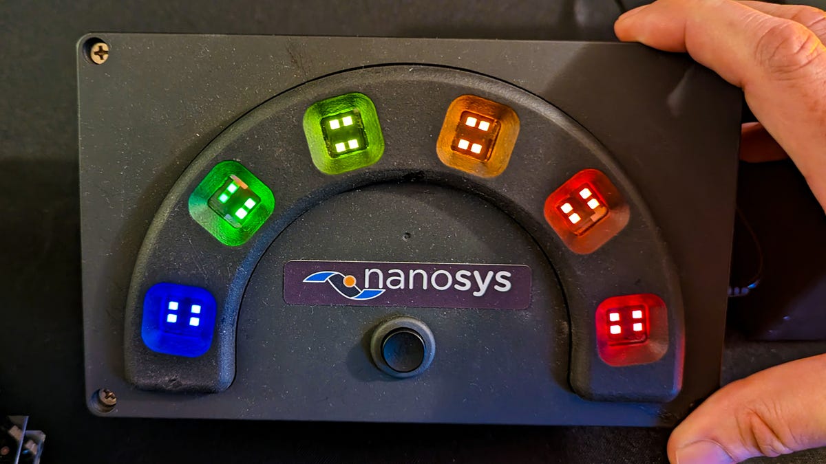 Uma caixa feita à mão mostrando um arco-íris de pixels iluminados por pontos quânticos eletroluminescentes.