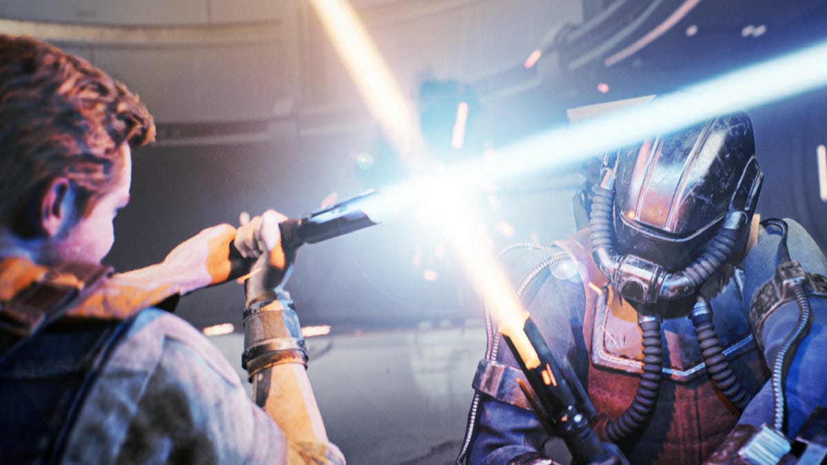 A man (Cal) defends himself with a lightsaber against a helmeted enemy attacking him with his own lightsaber.