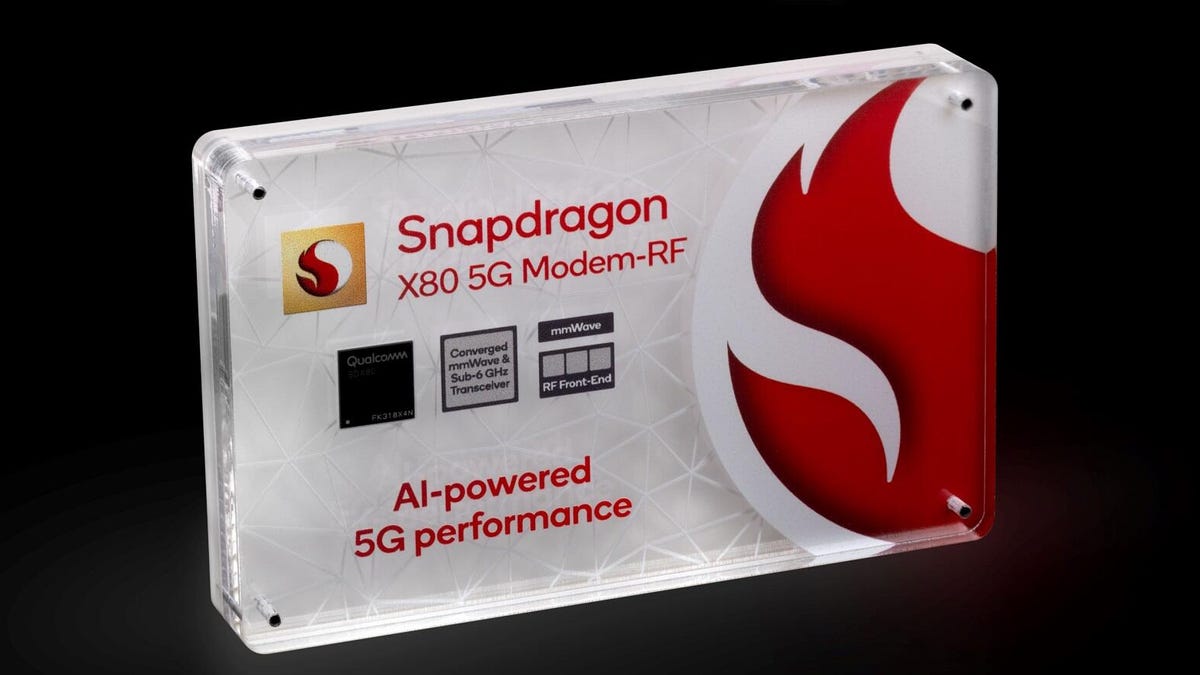 A modem chip sits encased in display plastic with lots of labeled writing and the Snapdragon logo.