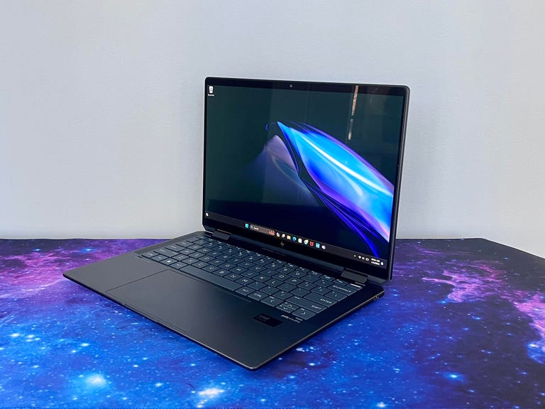 HP Spectre x360 14 Intel Core Ultra laptop at an angle against a gray wall