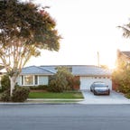 A suburban house with a Tesla Solar Roof at sunrise.
