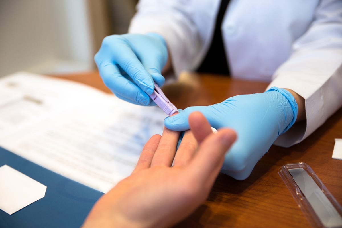 A person gets their finger pricked for an HIV test