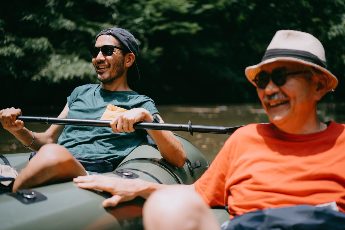 Two men rafting while wearing different types of hats