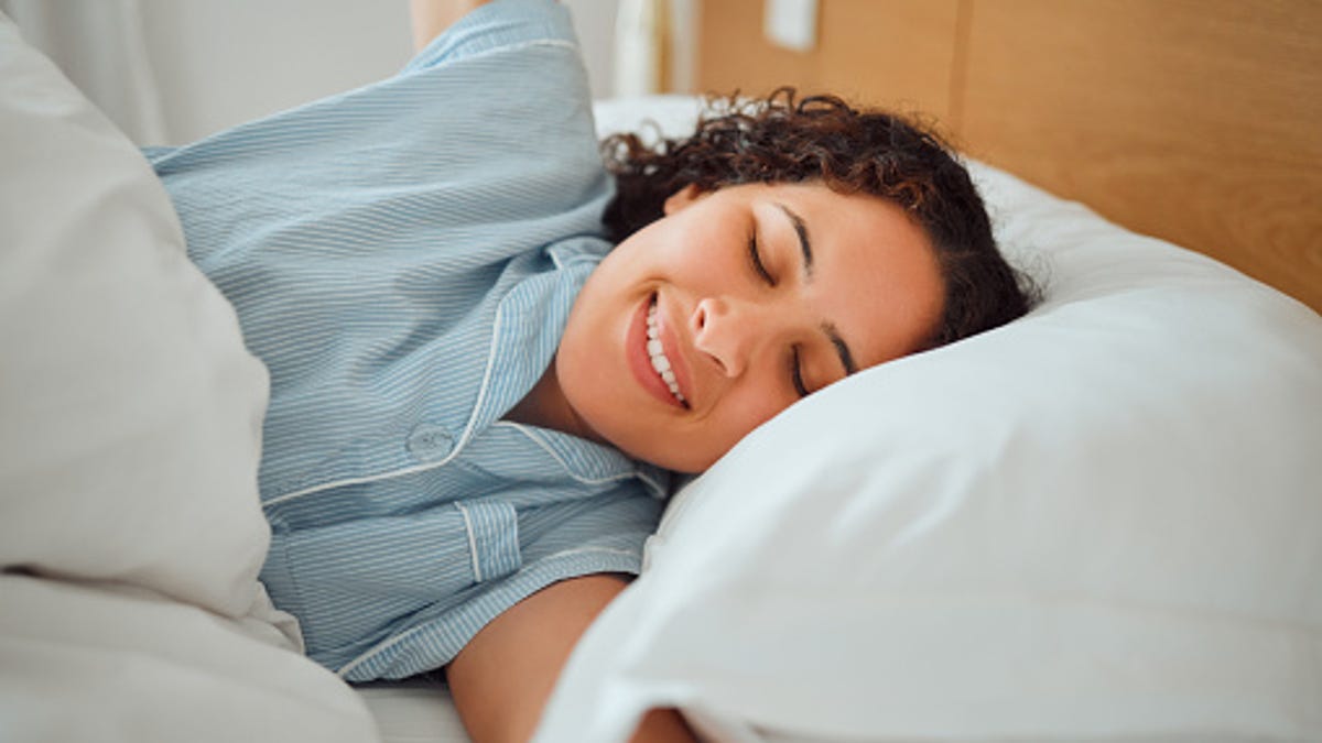 Woman smiling while waking up and stretching