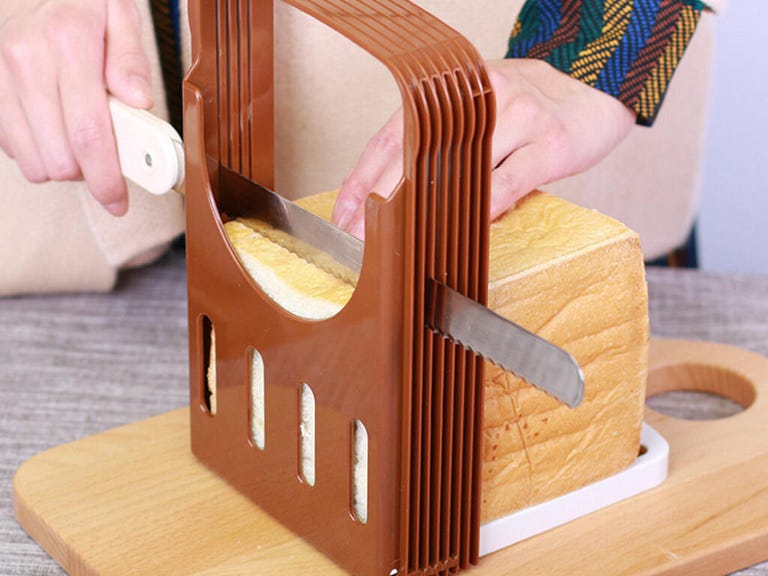 Cutting a loaf of bread using a slicer.