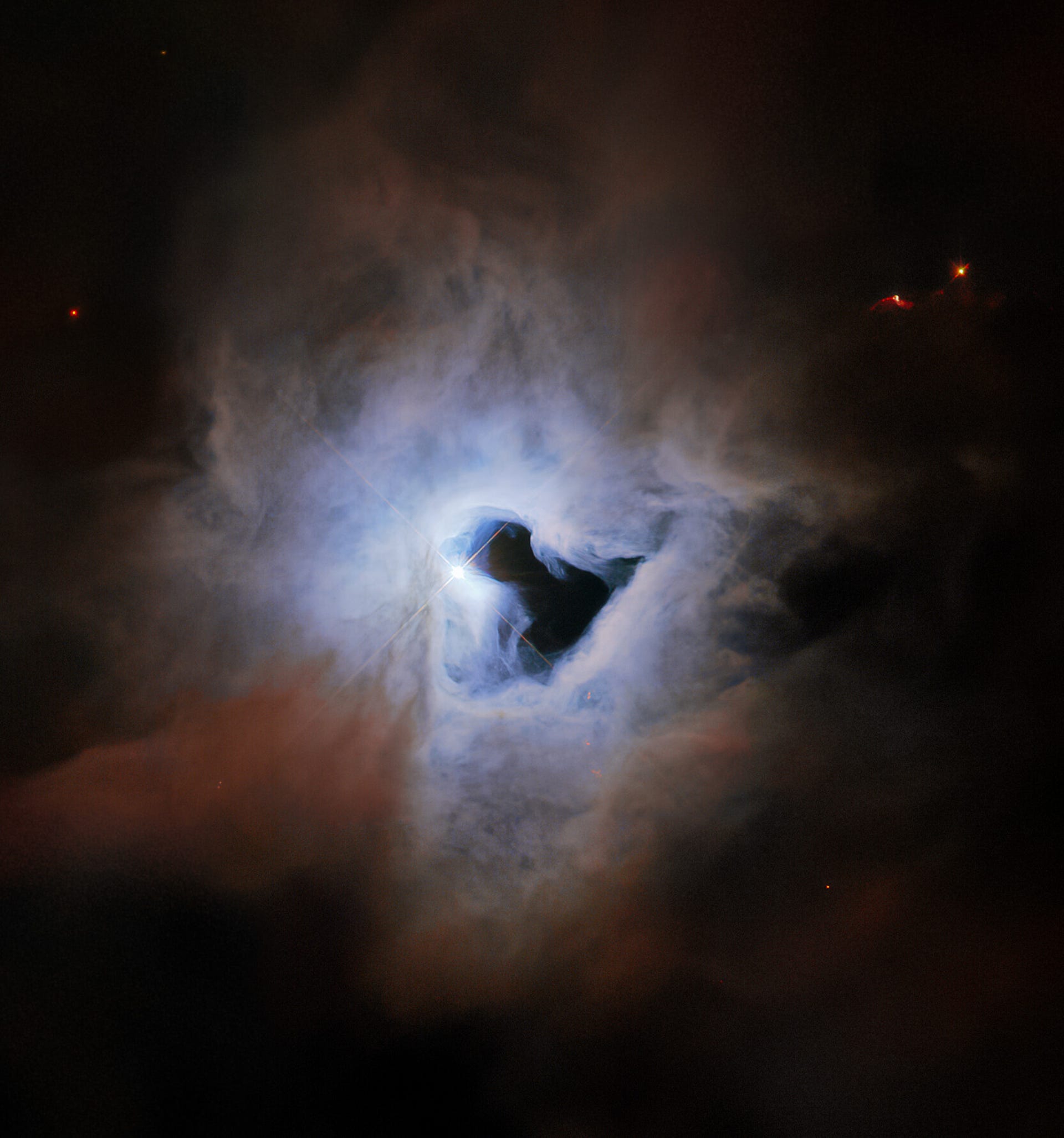 Ethereal view of a ghostly cloud with a dark, open spot in the center like a keyhole showing the dark of space behind.
