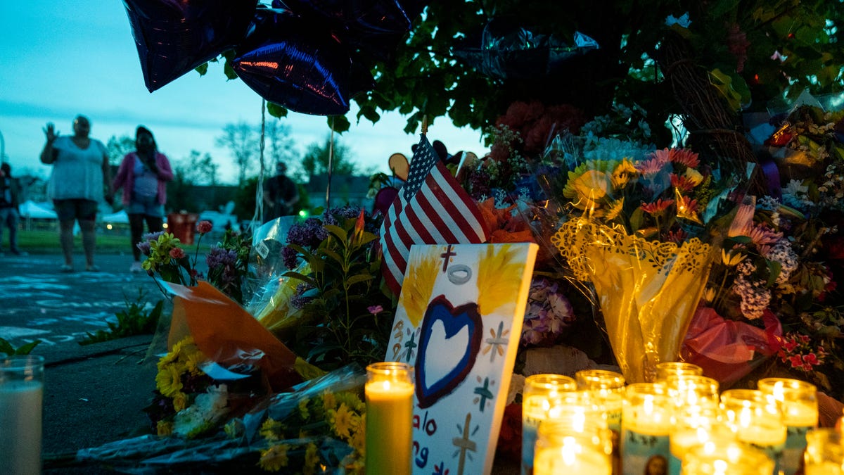 Candles, flowers and balloons are left behind at a scene of a mass shooting at Tops supermarket in Buffalo, New York.