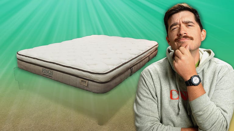 The Nest Bedding Finch mattress with against a colorful background with a man in a CNET shirt in the front.