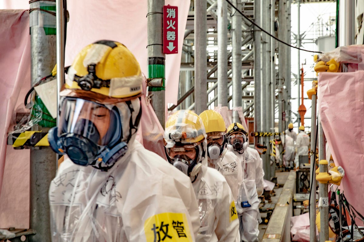Workers among the maze of valves and pipes inside the water purification facility at Fukushima Daiichi.