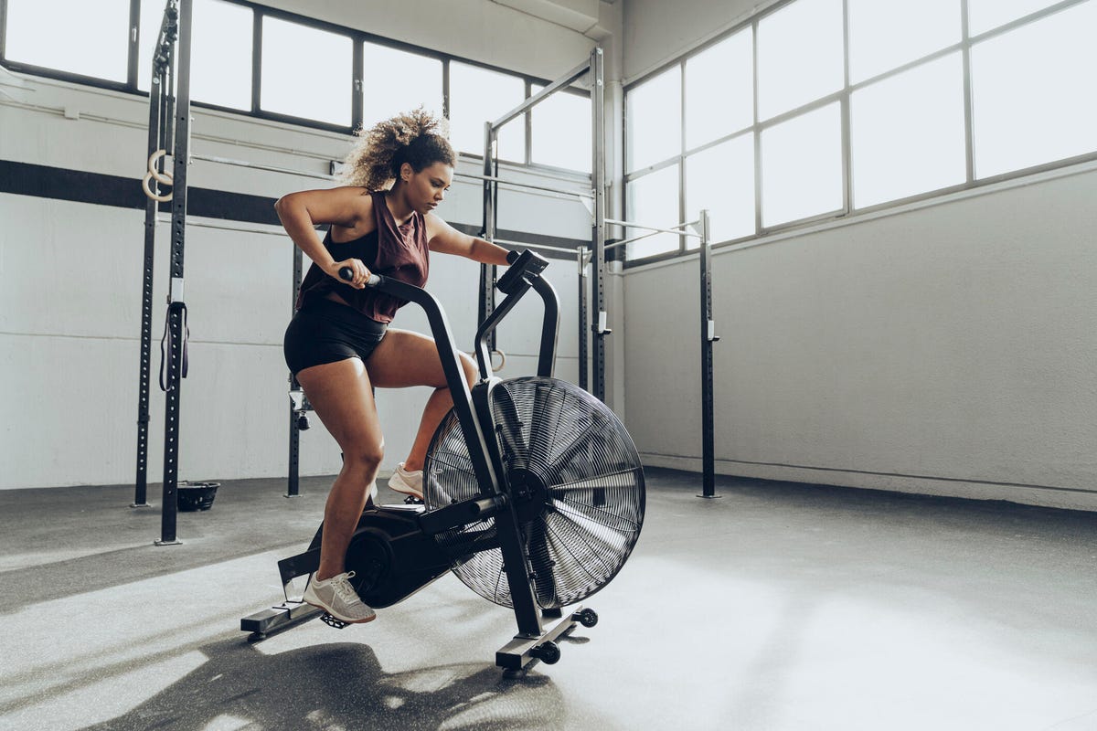 a woman riding a stationary bike in a garage gym