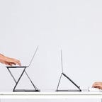 a person sitting and a person standing at a desk