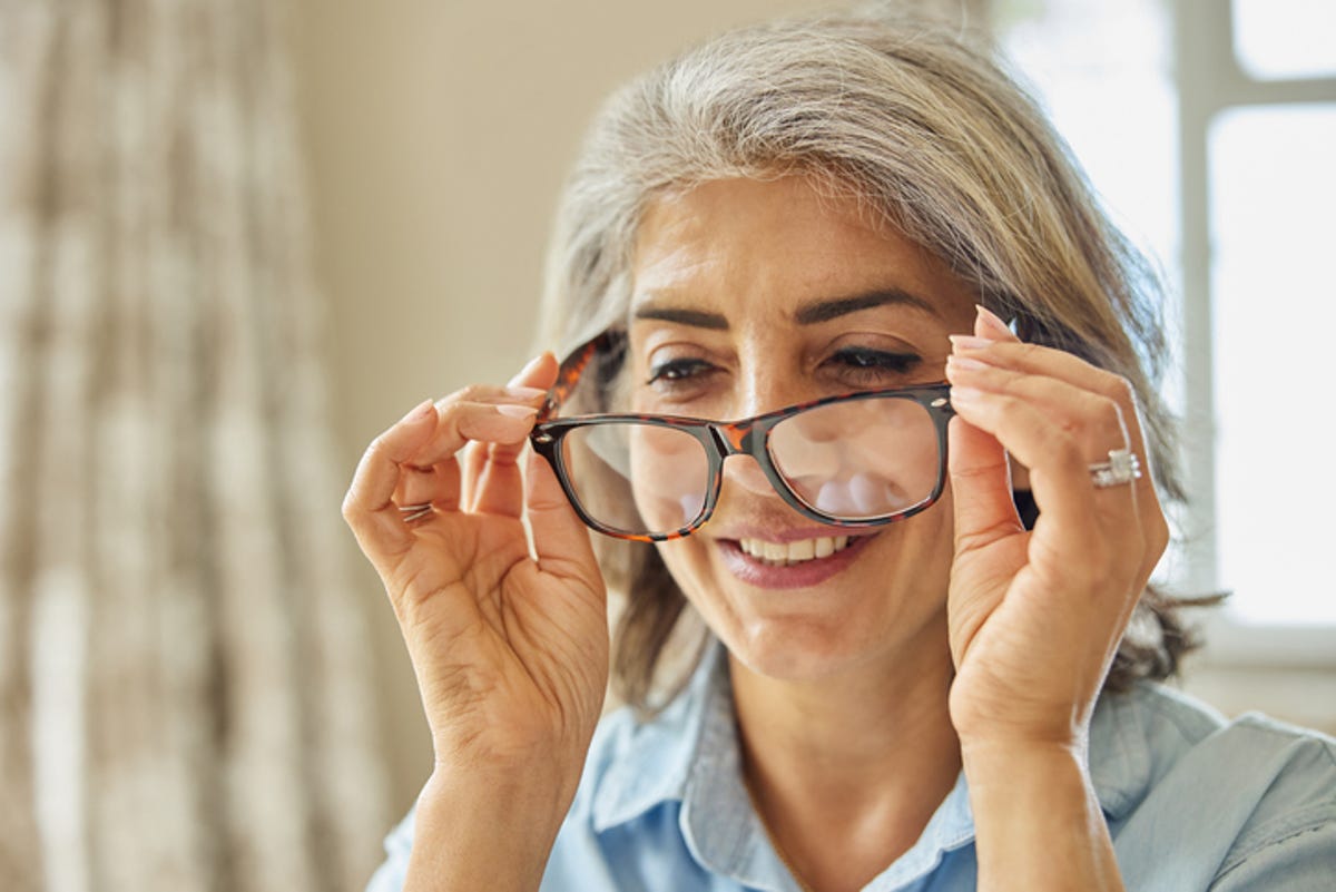 Woman trying on glasses at home.