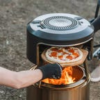 Solo stove pizza oven with pizza being pulled out