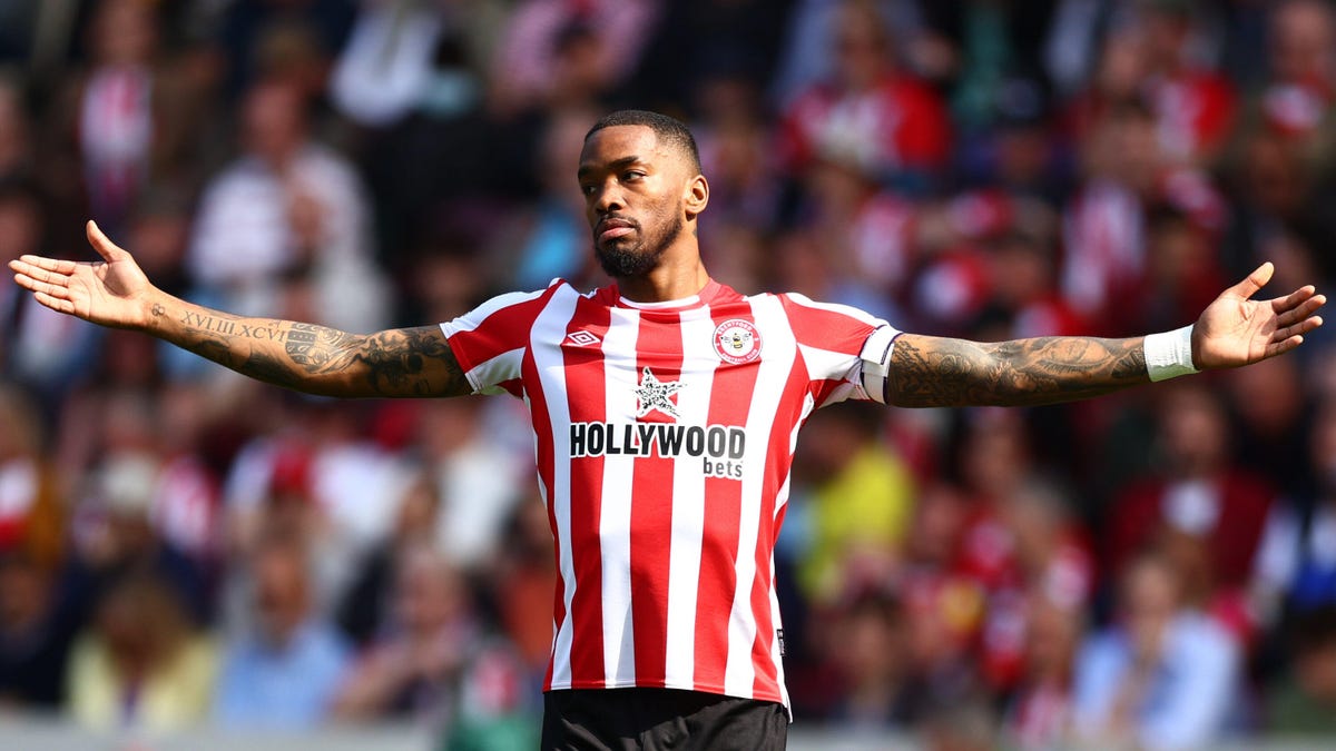 Brentford striker Ivan Toney standing with his arms outstretched.