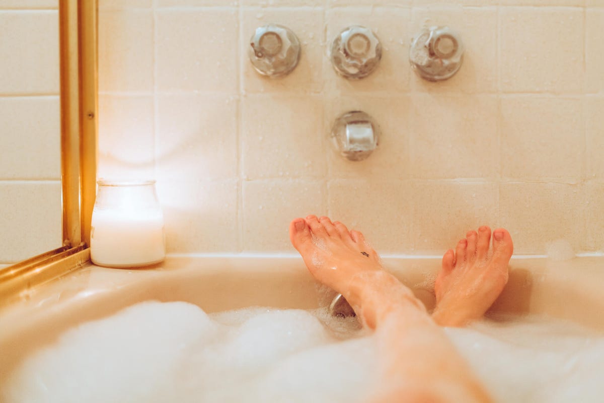 Bubble bath with person's feet propped up on the edge