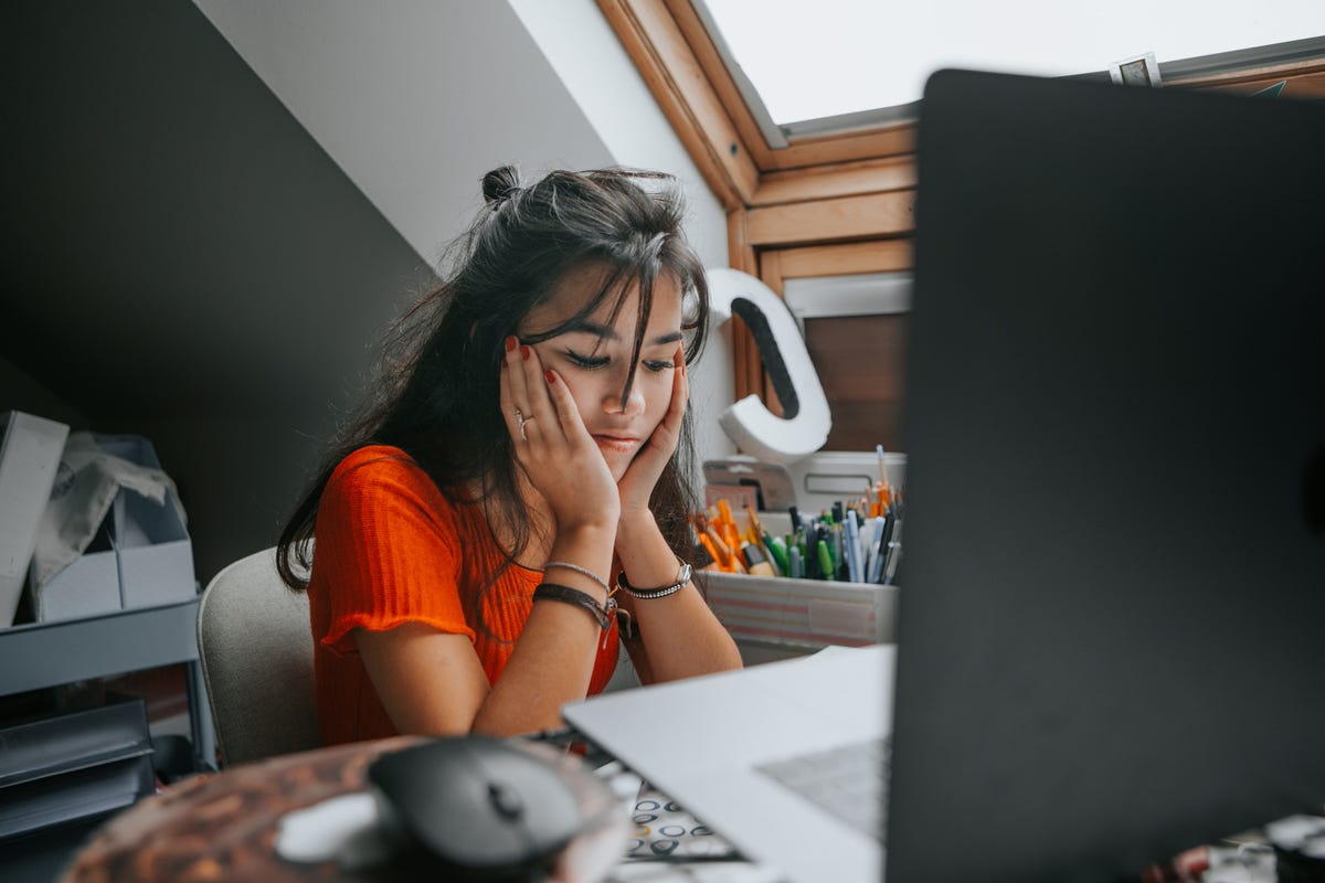 Young woman in front of computer feeling stressed