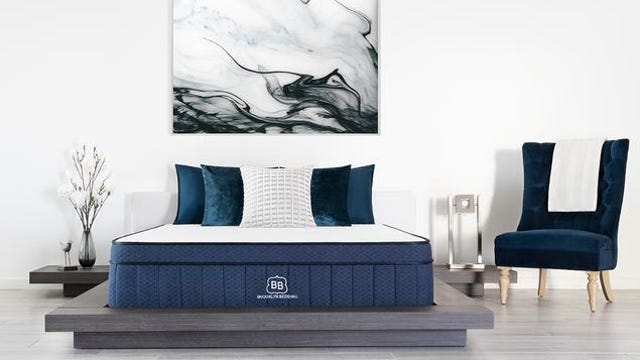 The cooling mattress from Brooklyn Bedding on a platform bed frame in a large white room