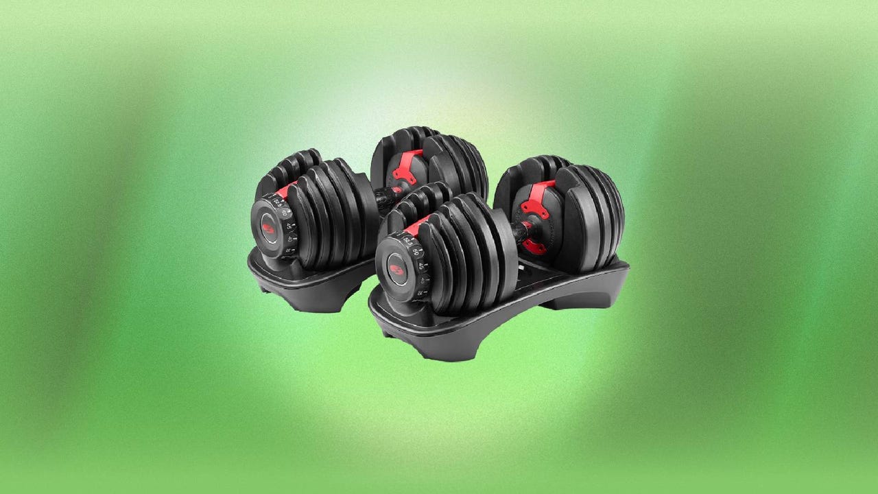 A pair of Bowflex adjustable dumbbells against a green background.