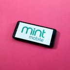 Mint Mobile logo on a phone on a pink background