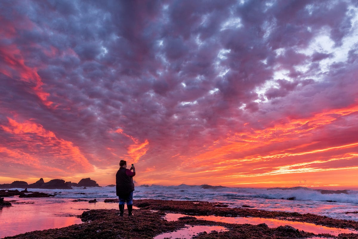 Alison Young photographs a brilliant sunset just after low tide at Pillar Point about 15 miles south of San Francisco. The rocks of Pillar Point just out into the Pacific Ocean toward the left; the Mavericks surfing competition takes place in the waves to