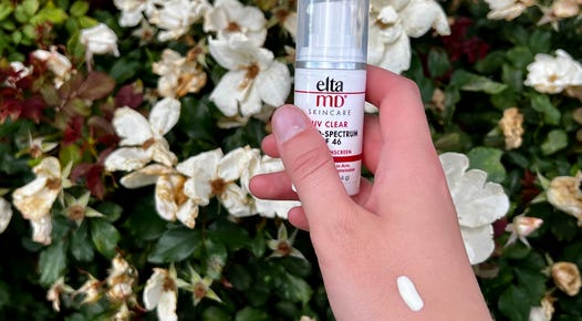 EltaMD UV Clear Sunscreen on hand in front of flowery background.