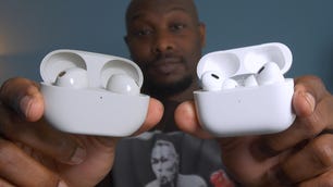 Jide Akinrinade holds two white sets of earbuds in their charging cases